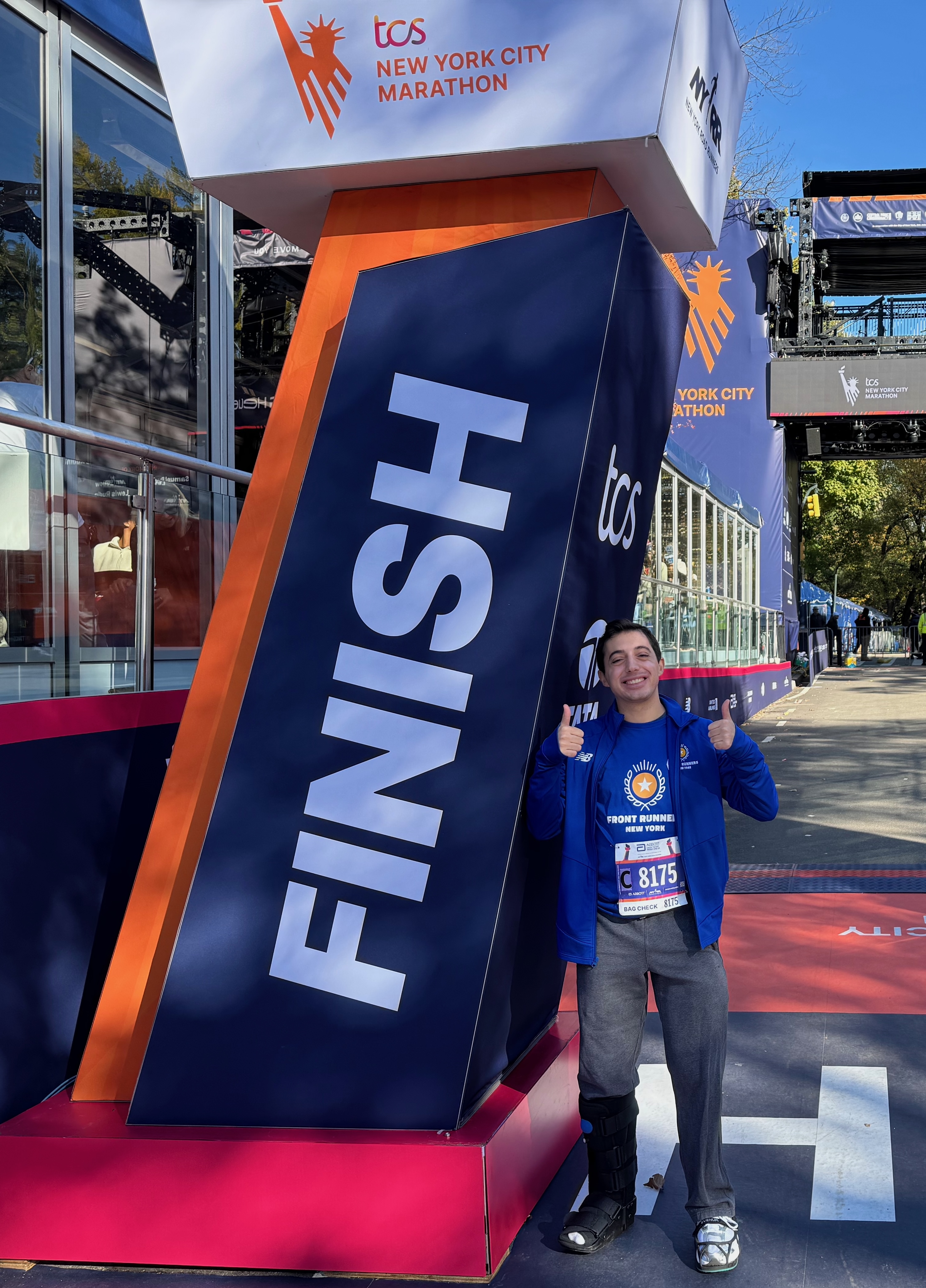Jack at the TCS New York City Marathon finish line, giving two thumbs up in his Front Runners New York jersey
