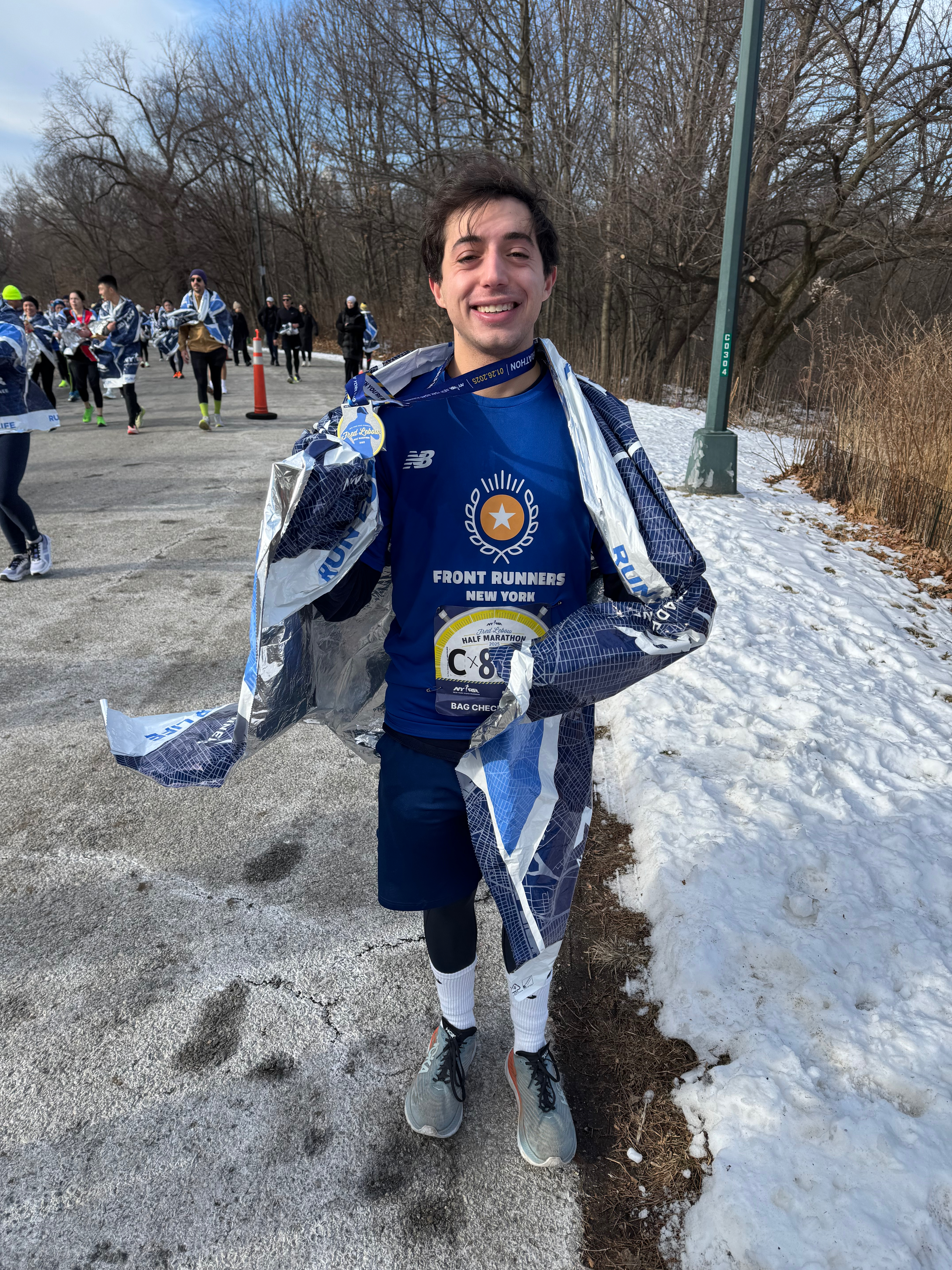 Jack wrapped in a mylar blanket after finishing a winter half marathon with Front Runners New York